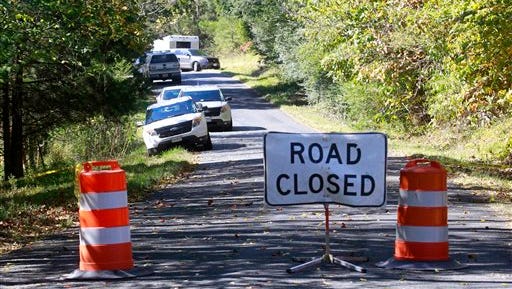 A road closed sign blocks traffic as authorities search a rural area where human remains were discovered in Albermarle County, Va., Sunday, Oct. 19, 2014. Investigators also interviewed residents in the area Sunday, and forensic teams combed the sides of a road for several miles past the site. Charlottesville Police Chief Timothy Longo said authorities have not yet confirmed that the remains are those of University of Virginia sophomore Hannah Graham, but have notified Grahams' parents of the discovery. (AP Photo/The Daily Progress, Andrew Shurtleff) 