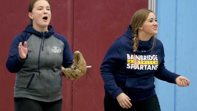 Bainbridge assistant softball coach Brittany Wisner, right, watches players catch outfield balls thrown by head coach Haylee Baker on Thursday. The pair helped lead the Spartans to the 2009 Class 3A state championship.