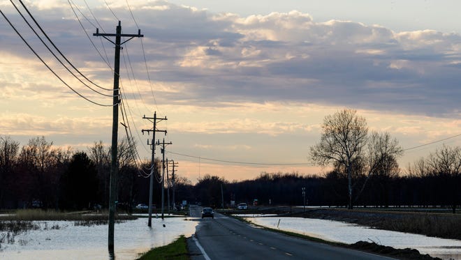 A car drives along US-60 as flood waters recede in Reed, Ky., Sunday, March 4, 2018. Last week this section of US-60 completely flooded and was not passable without an all-terrain vehicle. 