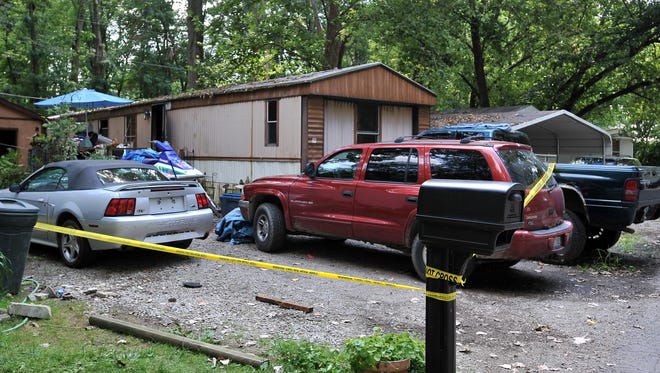 Fire line tape blocks off the driveway of a mobile home that caught fire Thursday night, July 31, 2014, in Walnut Township. Investigators are still trying to determine the source of the blaze that killed five dogs. Investigators now say the fire was intentionally set.