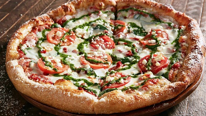 Mellow Mushroom’s Kosmic Karma pizza features a red sauce base with feta and mozzarella cheeses, spinach, sun-dried tomatoes and Roma tomatoes with a pesto swirl.