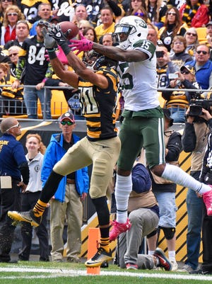 New York Jets wide receiver Brandon Marshall (15) catches a pass for a touchdown with Pittsburgh Steelers cornerback Ross Cockrell (31) defending during the first half of an NFL football game in Pittsburgh, Sunday, Oct. 9, 2016.