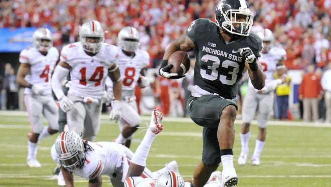 MSU's Jeremy Langford breaks through the Ohio State defense for MSU's final touchdown with less than three minutes to play in last year's Big Ten championship game.