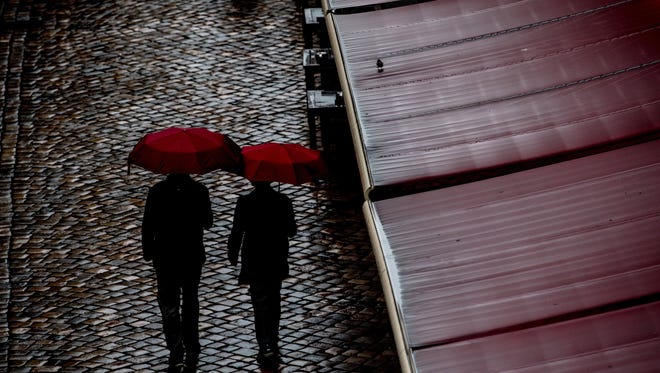 A couple walk under umbrellas during a rainy weather in Dresden, Germany, June 29, 2017.