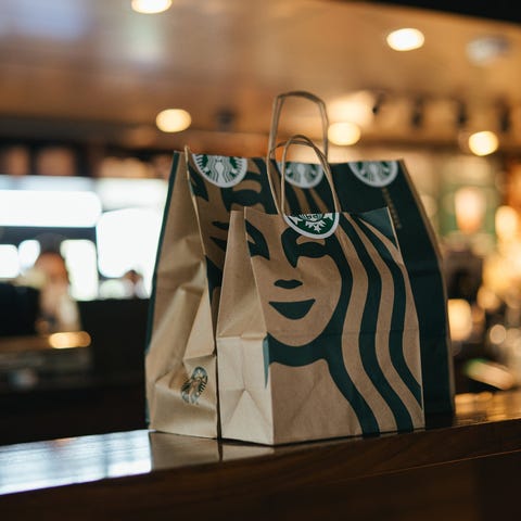 Two Starbucks bags wait on the store counter for p