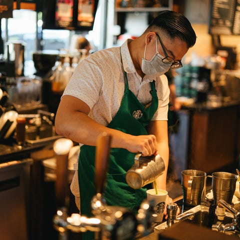 Starbucks barista crafting customer drink.