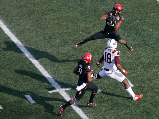 Bearcats safety Zach Edwards leaps to intercept the ball over Virginia Tech wide receiver Cam Phillips in the first quarter.