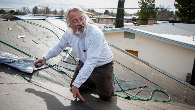 Working for general contractor Terry Giever, Gary Saxton helps repair a roof in Las Cruces severely damaged by hail. Accorded to Giever at least 700 permits for roof repair have been requested since the hail storms that hit Las Cruces in October.