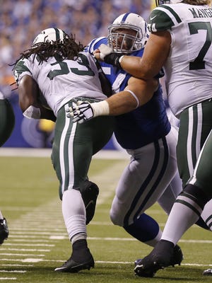 Indianapolis Colts nose tackle David Parry (54) works to hold on to New York Jets running back Chris Ivory (33) as he breaks into the line during the first half of a NFL Monday Night Football game, Monday, September 21, 2015.