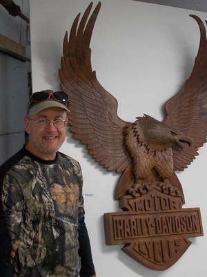 Artist Mike Sponholz stands next to his sculpted eagle modeled after the Harley Davidson symbol. Sponholz will create a snow sculpture during Mishicot’s Winterfest celebration.