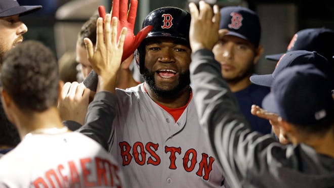 
Boston Red Sox’s David Ortiz high-fives teammates in the dugout after hitting a two-run home run in the 10th inning against the Orioles, on Friday in Baltimore. Boston won 5-3. 
