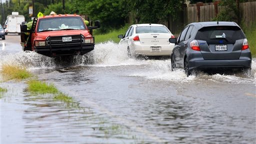 Vehicles drive in flooded waters caused by a heavy rains Wednesday, June 17, 2015, on Glenoak Drive in Corpus Christi, Texas. (Gabe Hernandez/Corpus Christi Caller-Times via AP) 