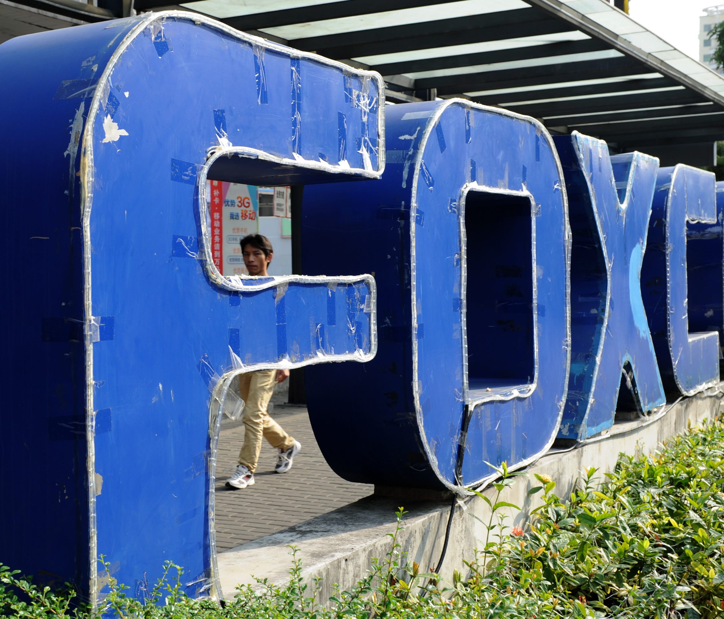 This picture taken on February 22, 2013 shows a young man walking past a Foxconn recruitment point in Shenzhen, south China's Guangdong province.
