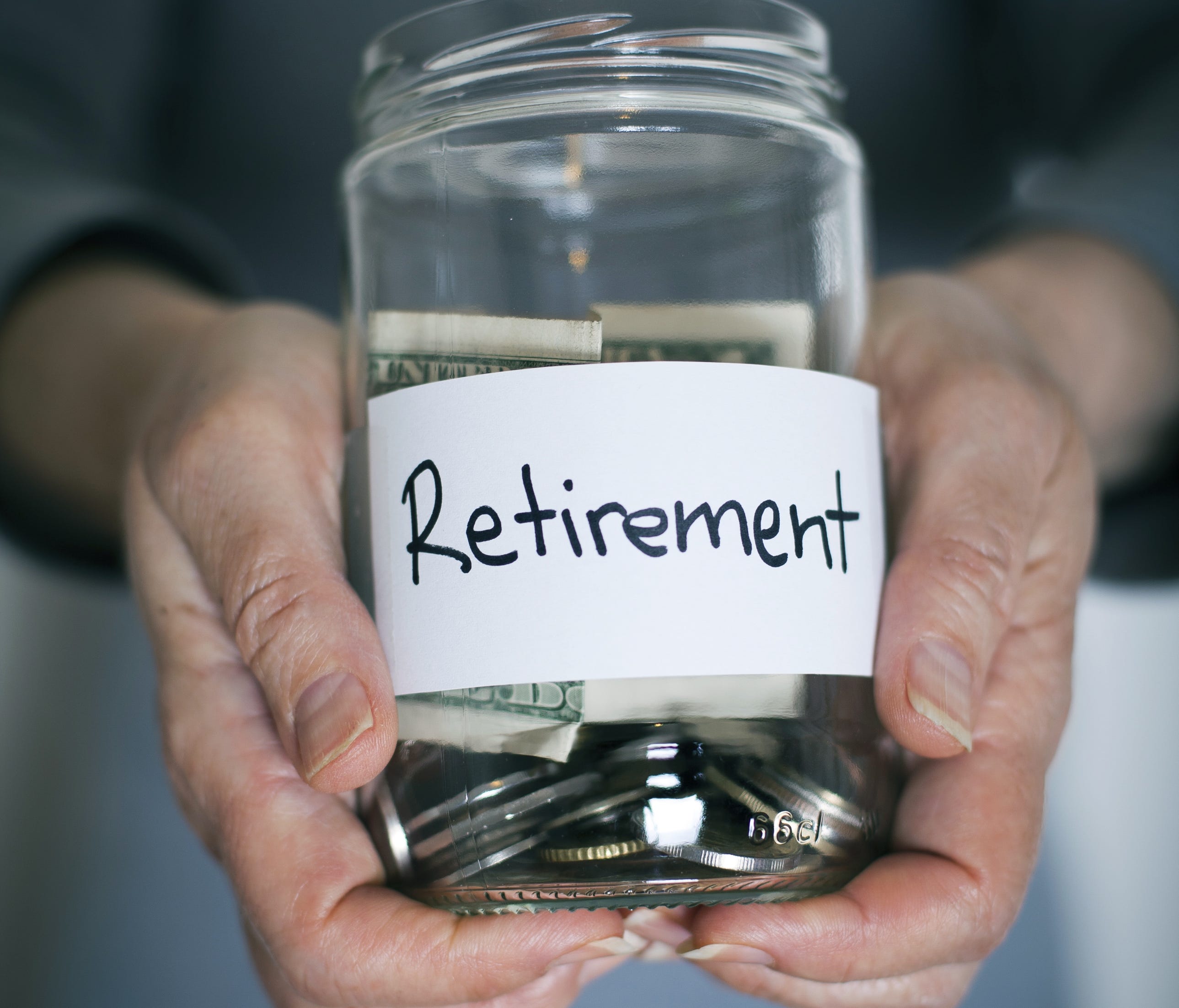 Photo illustration created in 2014 shows retirement savings in a glass jar.