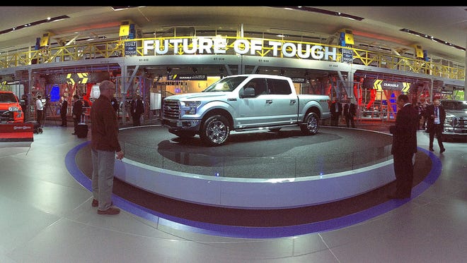 Journalists walk around the 2015 Ford F-150 aluminum-body truck in Cobo Center during the 2014 North American International Auto Show held in  Detroit.