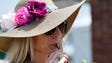 Samantha Fishburn wears a derby hat and drinks a mint