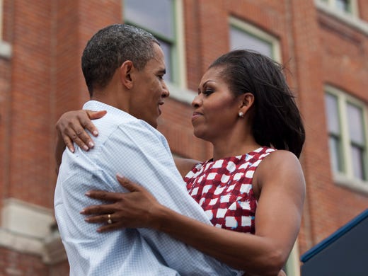 President Obama and Michelle hug as they take the stage