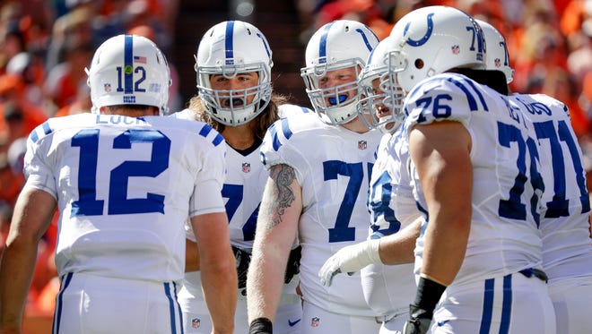 The Indianapolis Colts offensive line listens as quarterback Andrew Luck (12) relays the play during the first quarter against the Denver Broncos at Sports Authority Field at Mile High in Denver on Sunday, September 18, 2016.