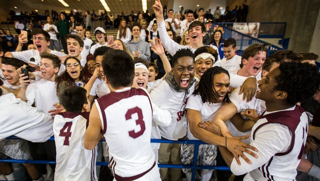 Caravel players celebrate with their fans following Caravel Academy's 66-56 win over Sanford School in the quarterfinals of the DIAA Boy's Basketball Tournament at the Bob Carpenter Center in Newark on Sunday afternoon.