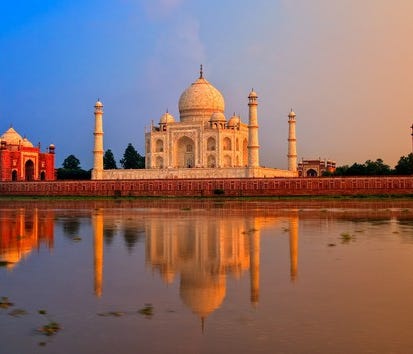 Taj Mahal with two other buildings and the Yamuna River in the foreground.