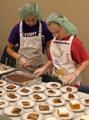 Volunteers Emalyn Glinn, 10, left, Kaitlin Anderson, 11,  place dessert treats on plates at Welcome Table Tuesday October 28, 2014 at Redeemer Lutheran Church in Plymouth.