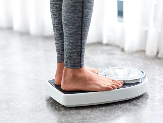 A girl standing on home scales.