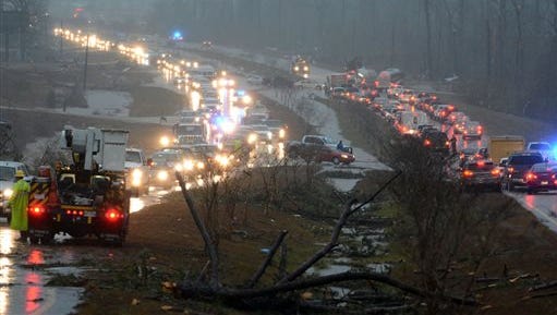 Traffic is blocked on US 98 East near Columbia, Miss., after a tornado touched down around 2:30 p.m., Tuesday, Dec. 23, 2014. Gov. Phil Bryant declared an emergency for two southeastern counties where officials say four people died in the storms and several more were injured. His office said thousands were without power Tuesday night around Columbia, which is about 80 miles southeast of Jackson. (AP Photo/The Hattiesburg American, Eli Baylis)