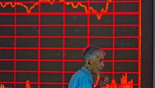 A Chinese investor walks past a display of the Shanghai Composite Index at a brokerage in Beijing on Thursday, Aug. 27, 2015. China's key stock market index surged 5.3 percent Thursday, its biggest gain in eight weeks, as markets across Asia rose following Wall Street's rebound, giving investors some relief after gut-wrenching global losses. (AP Photo/Ng Han Guan)