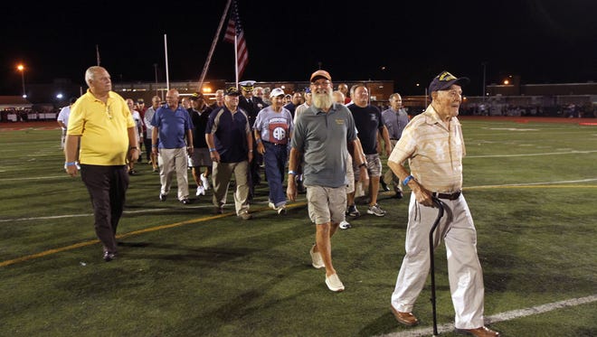 98-year-old World War II Air Force Veteran Steve Bolcar, r, leads a group  of Veterans on the Boonton High football field as the school honored its graduate military veterans during halftime of the Boonton High School football game Friday night. The vets, some of whom are still residents, others coming back from out of town, also enjoyed a tailgate party prior to the game and ceremony.