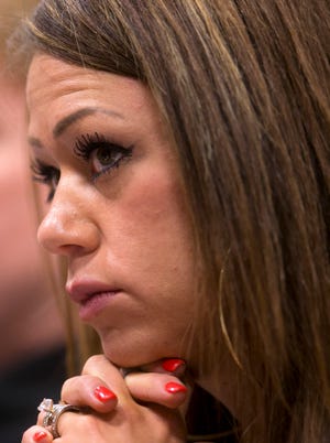 Juliann Ashcraft, the widow of Andrew Ashcraft, one of the 19 fallen firefighters from the Yarnell Hill Fire, listens during a Phoenix hearing in December 2013 on the workplace safety investigation of the fire.