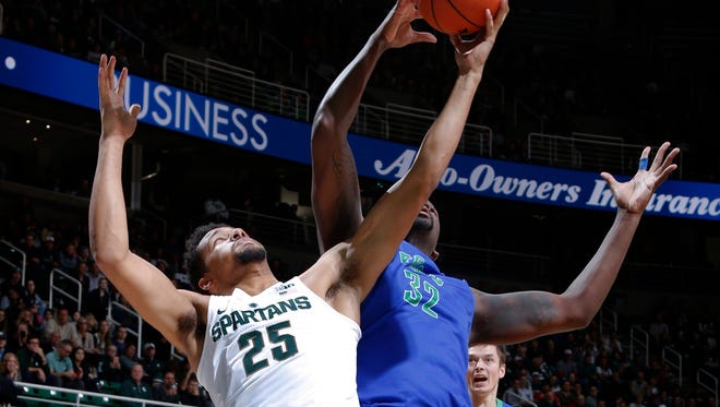 Michigan State's Kenny Goins (25) and Florida Gulf Coast's Antravious Simmons reach for a rebound during the first half of an NCAA college basketball game, Sunday, Nov. 20, 2016, in East Lansing, Mich. (AP Photo/Al Goldis)