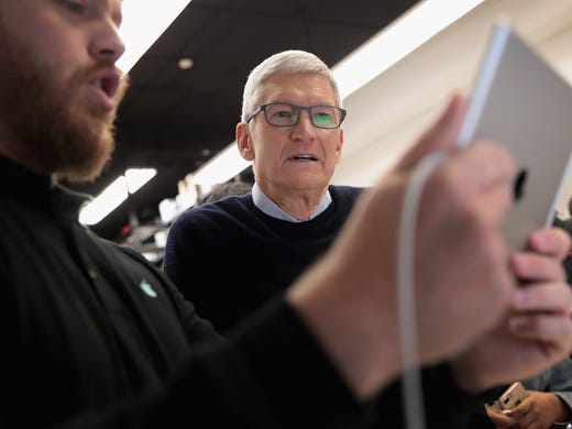Apple CEO Tim Cook gets a demonstration of an app during
