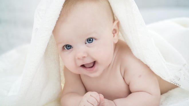 baby looking at camera under a white blanket