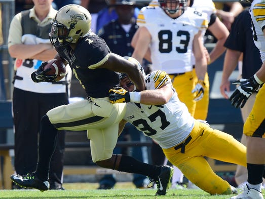 Sep 27, 2014; West Lafayette, IN, USA; Purdue Boilermakers running back Akeem Hunt (1) carries the ball as Iowa Hawkeyes defensive back Jordan Lomax (27) tackles during the first quarter at Ross Ade Stadium. Mandatory Credit: Marc Lebryk-USA TODAY Sports