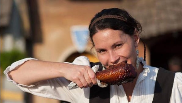 A wench digs in to a turkey leg, one of the most popular food offerings at the Minnesota Renaissance Festival.