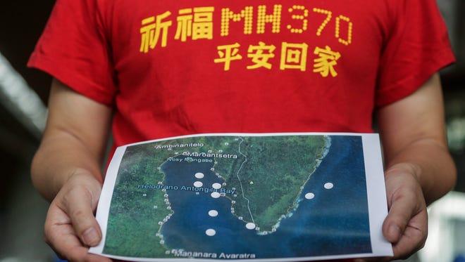 MH370 next-of-kin Jiang Hui from China holds a map during a press conference at Kuala Lumpur International Airport in Sepang, Malaysia, Dec. 3, 2016, before their trip to Madagascar.