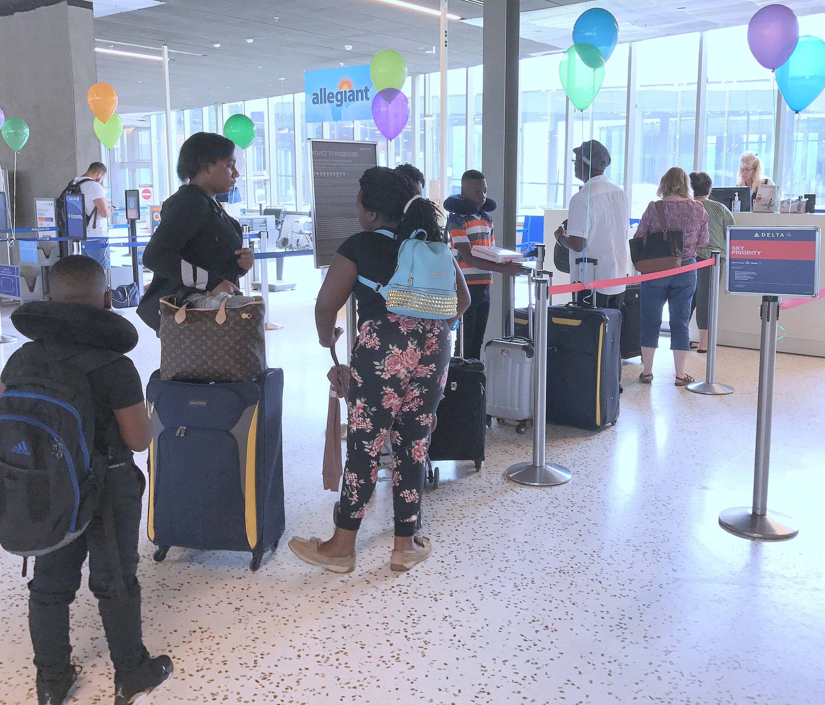 Passengers line up at a temporary ticket counter in the new terminal at the Elmira Corning Regional Airport.