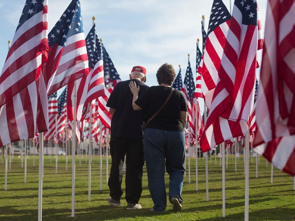 Tambra Hofstetter, right, comforts her husband, Bruce Hofstetter, Nov. 6 at Handy Park in Orange, Calif., after visiting a flag honoring his high school friend Leo Green. Bruce Hofstetter said Green served in the Army during the Vietnam War. American