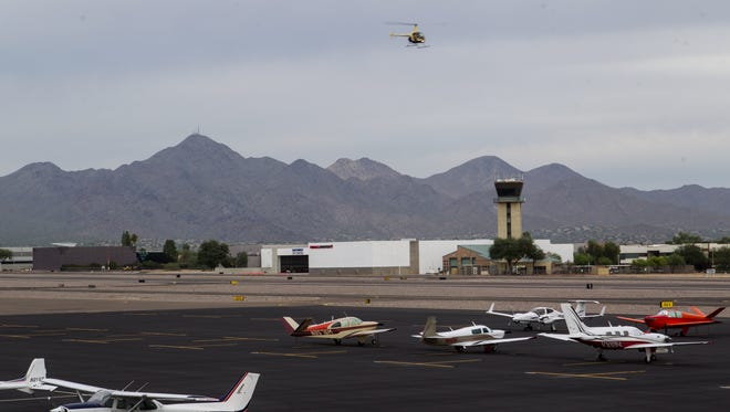 A helicopter flies over the tarmac at Scottsdale Airport on Thursday, Oct. 15, 2015.