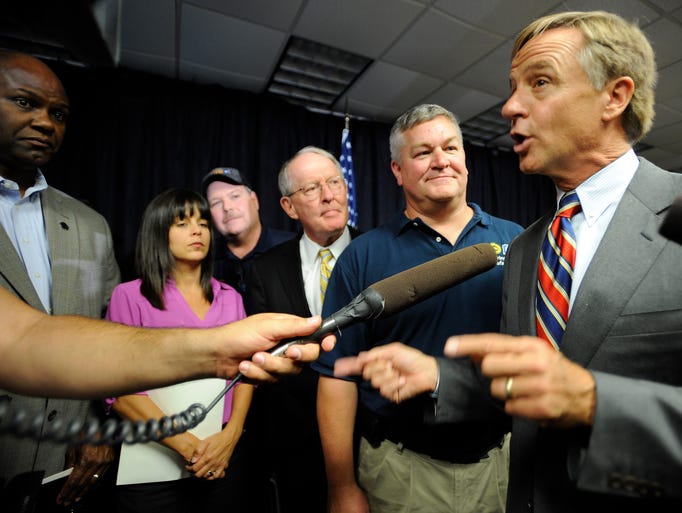 Tennessee Gov. Bill Haslam talks to the media as they crowd around speakers after GM announced Wednesday, Aug. 27, 2014, it will build the next-generation Cadillac SRX at its big Spring Hill plant and will invest another $185 million for new engines to be built at the complex, retaining 390 jobs.