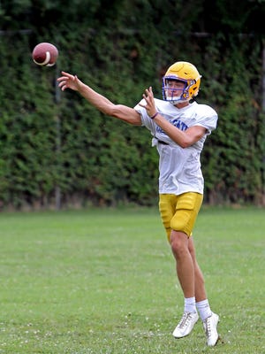 NewCath quarterback Patrick Henschen rolls out to pass during a practice.