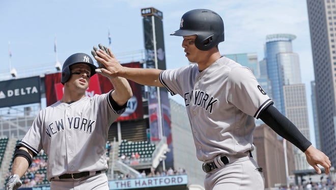 New York Yankees' Brett Gardner, left, congratulates Rob Refsnyder after he scored on Gardner's sacrifice fly off Minnesota Twins pitcher Ryan Pressly in the ninth inning of a baseball game Saturday, June 18, 2016, in Minneapolis.