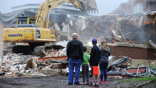 From left, Richard Krueger, who lives near Mark Twain Elementary School, and his grandchildren Ayden Poulos, 9, who was a third-grader last year at Mark Twain, Austin Poulos, 15, and Amelia Poulos, 11, who was a fifth-grader last year at Mark Twain, look on as construction crews tear down Mark Twain Elementary School on Tuesday, May 26, 2015, in Sioux Falls. 