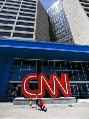 Pedestrians pass the entrance to CNN headquarters in Atlanta.