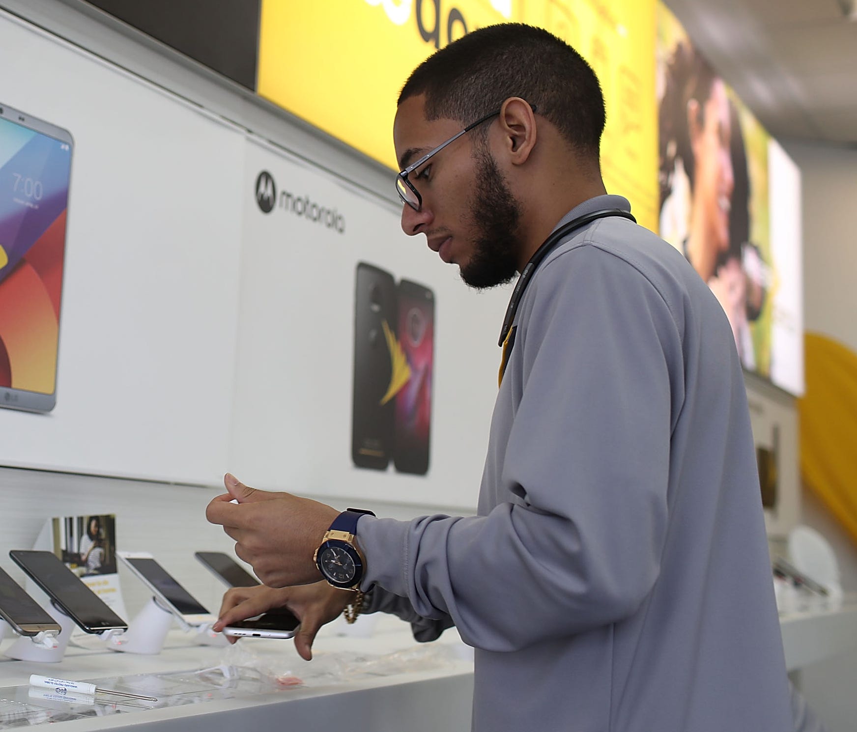 Jeffrey Quintana a sales rep at a Sprint store works on a cell phone display on Aug. 1, 2017 in Miami, Fla.