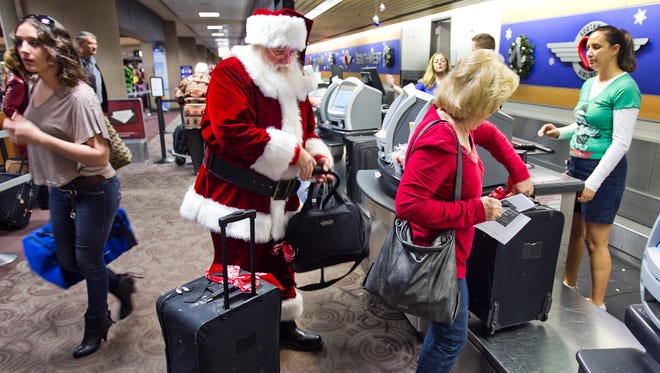 Holiday travelers check in at the Southwest Airlines counter at Phoenix ...