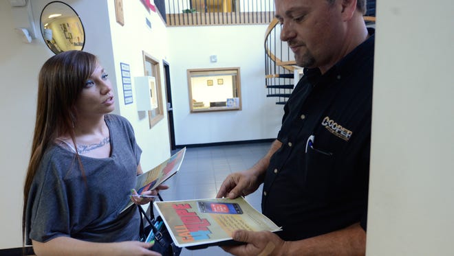 After being recognized Aug. 7 by Stephen Eagle, Cassie Nygren explains her work posting fliers for Rise Together in the Marinette police station.