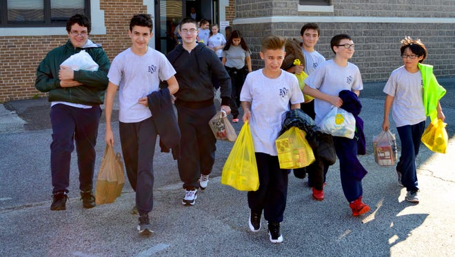 (Front, from left) Connor Baker, Dominic Forgen, Anthony Kristovich, D'Amani Almodovar, Samson Gerner, Christopher Fanelli and Christopher Bernard and other eighth graders from Bishop Schad Regional School deliver canned goods to St. Vincent de Paul Society.