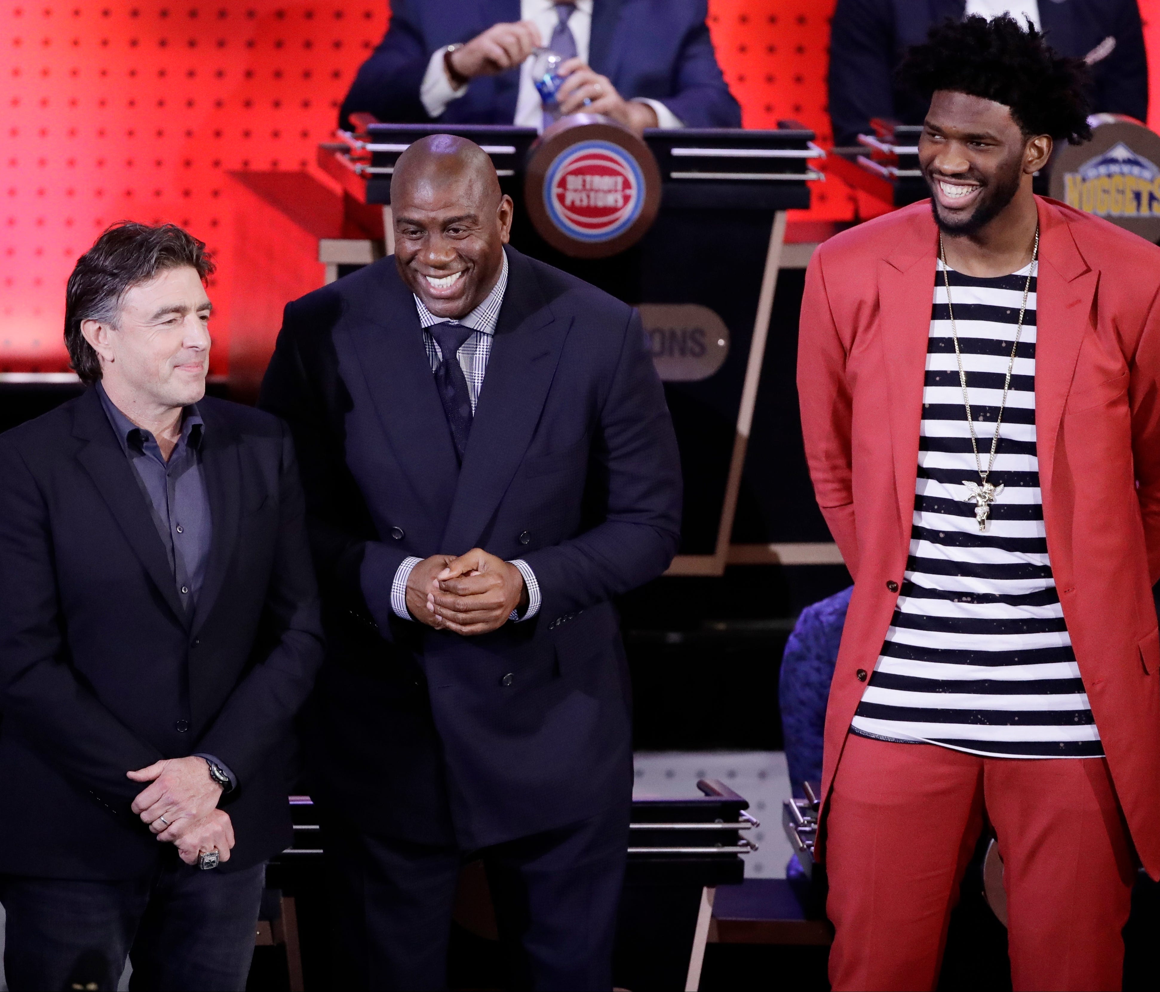 Boston Celtics co-owner Wyc Grousbeck, left, Magic Johnson, president of basketball operations for the Los Angeles Lakers, center, and Philadelphia 76ers' Joel Embiid, right, react after the learning they will get one of the first three picks at the 
