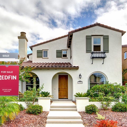 A house with a Redfin for sale sign.